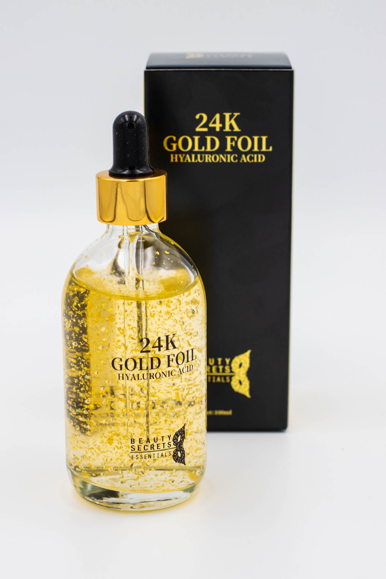 Luxurious gold colored liquid in a bottle and its box in white background that helps in hydration of your skin.